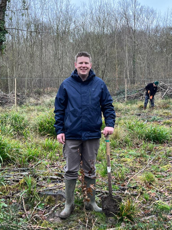 Man digging wearing wellies.